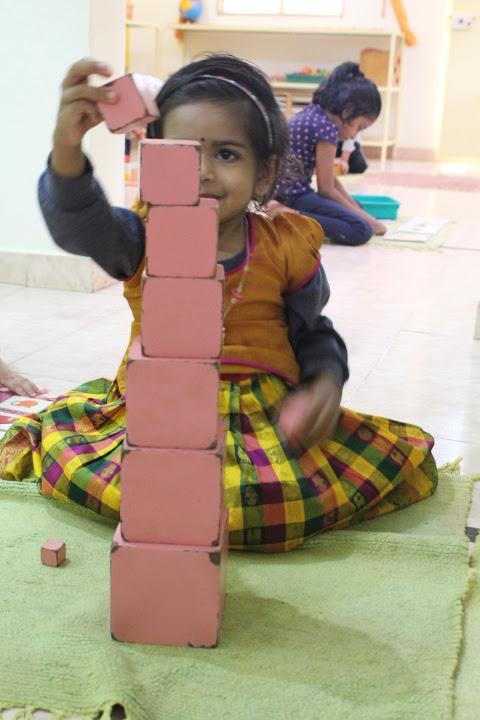 Child playing with wooden blocks - Montessori Materials